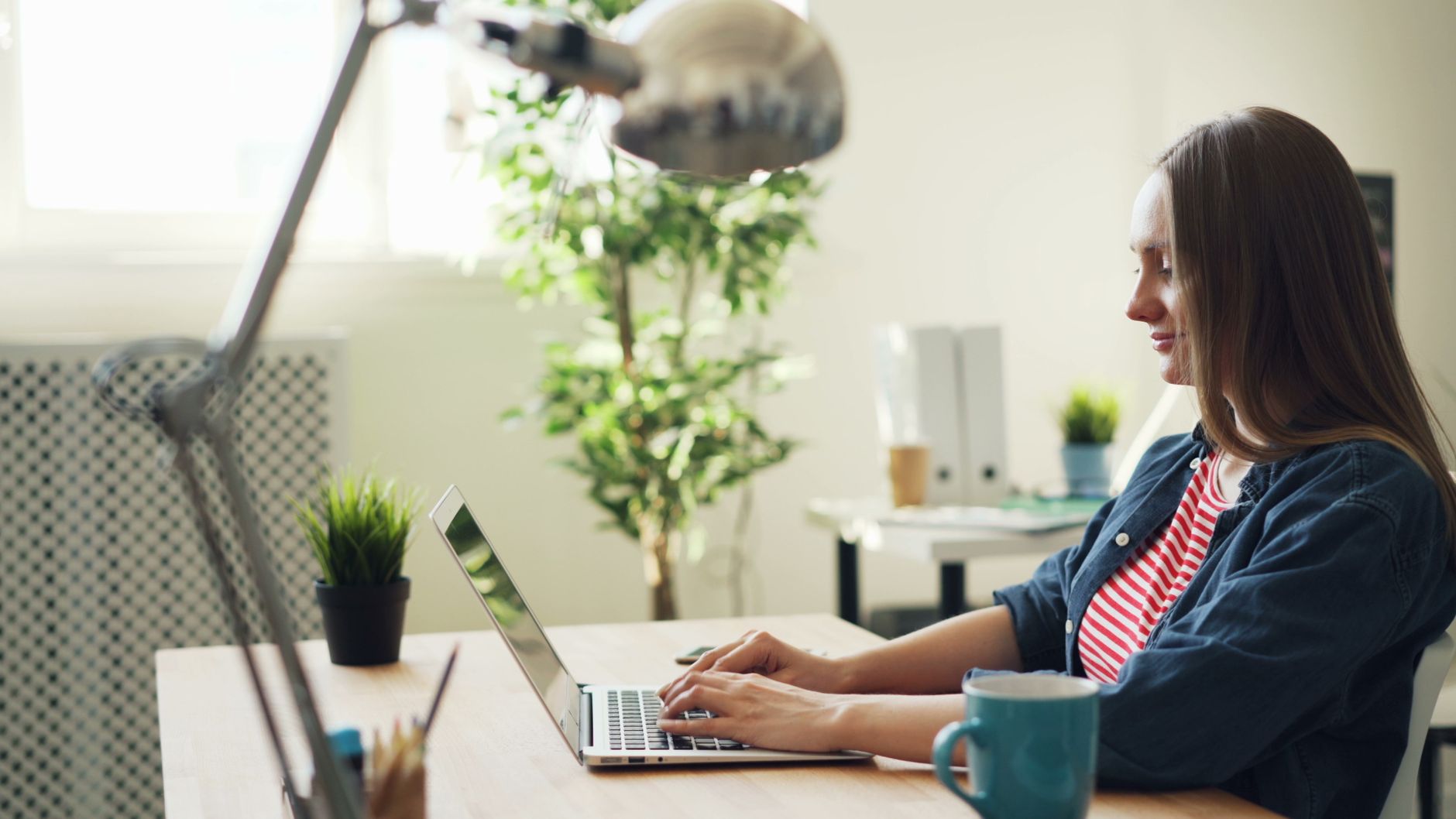 Person working on a laptop in a bright home office