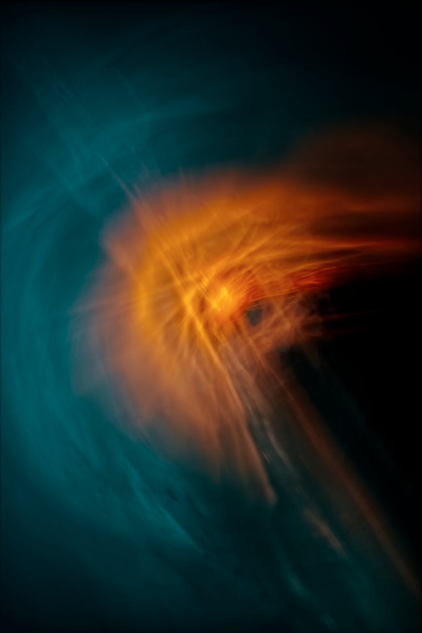 A vibrant abstract design with swirling energy in blue and orange tones, evoking cosmic motion.