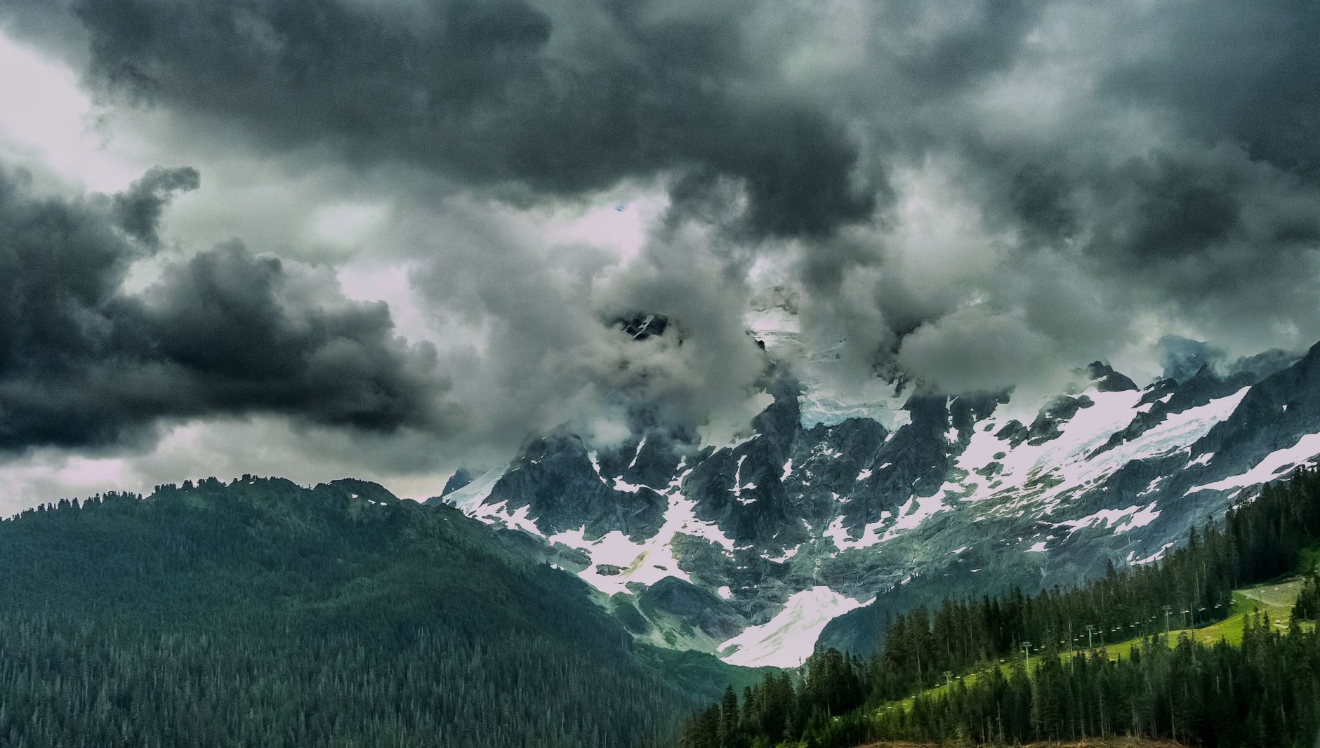 Snow-covered mountains beneath storm clouds for weather and environment videos