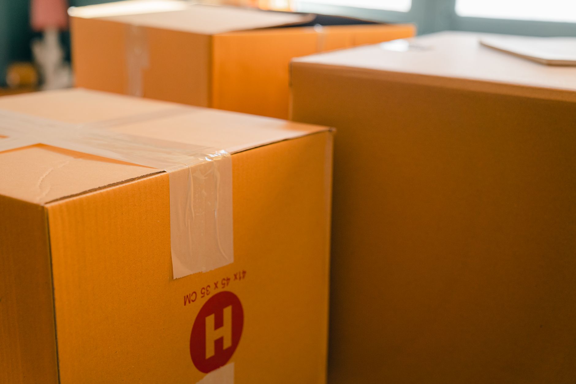 Sealed cardboard moving boxes in a bright room ready for relocation