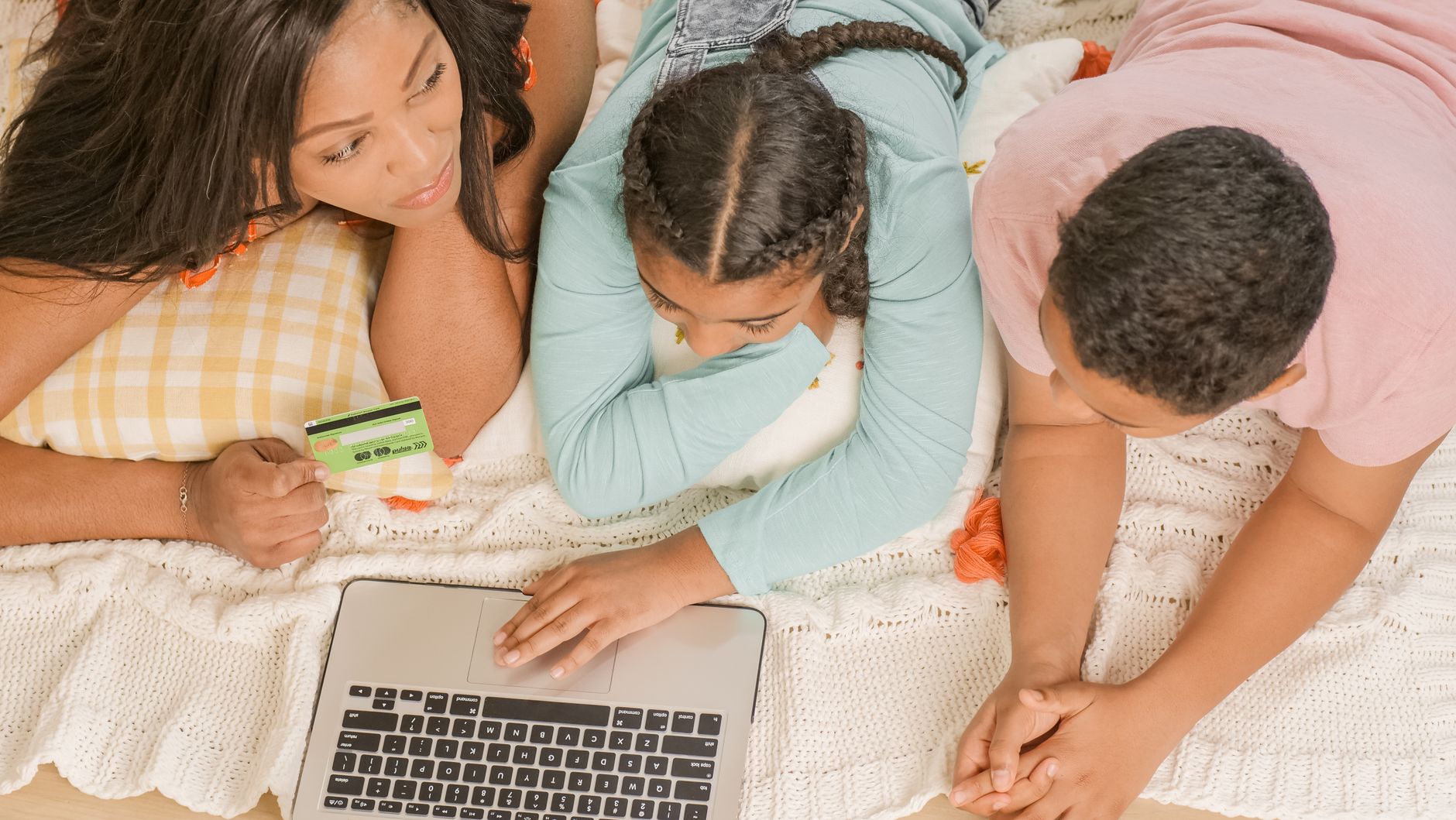 Parent and children using a laptop together at home