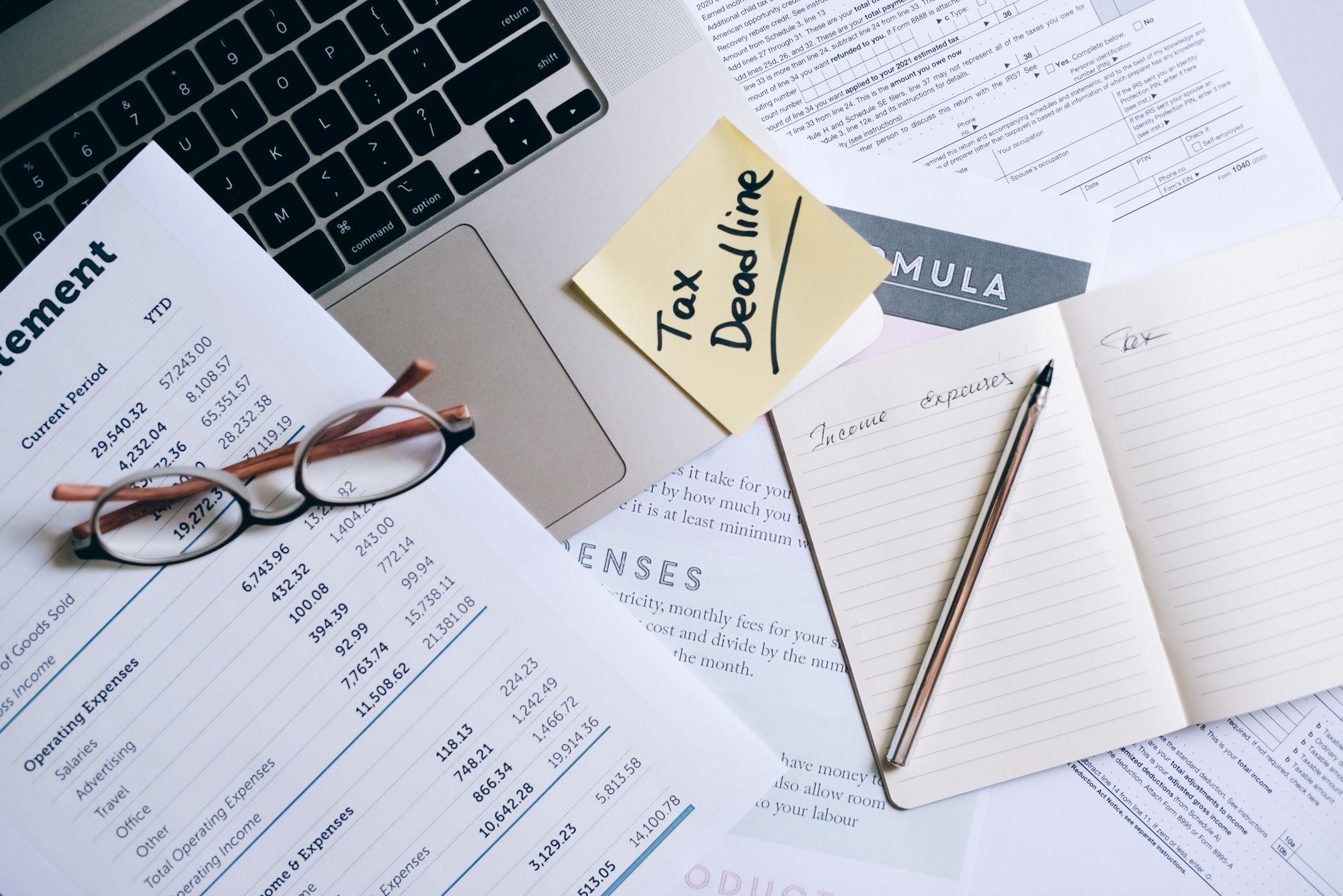 Laptop and paperwork on a desk used for reviewing Starlink billing records.