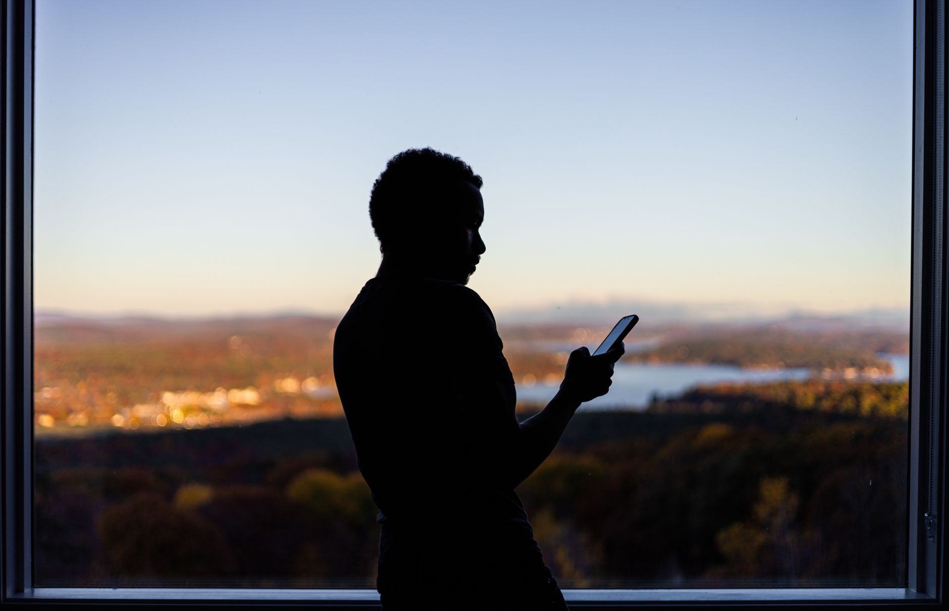 Person checking a smartphone with a landscape in the background