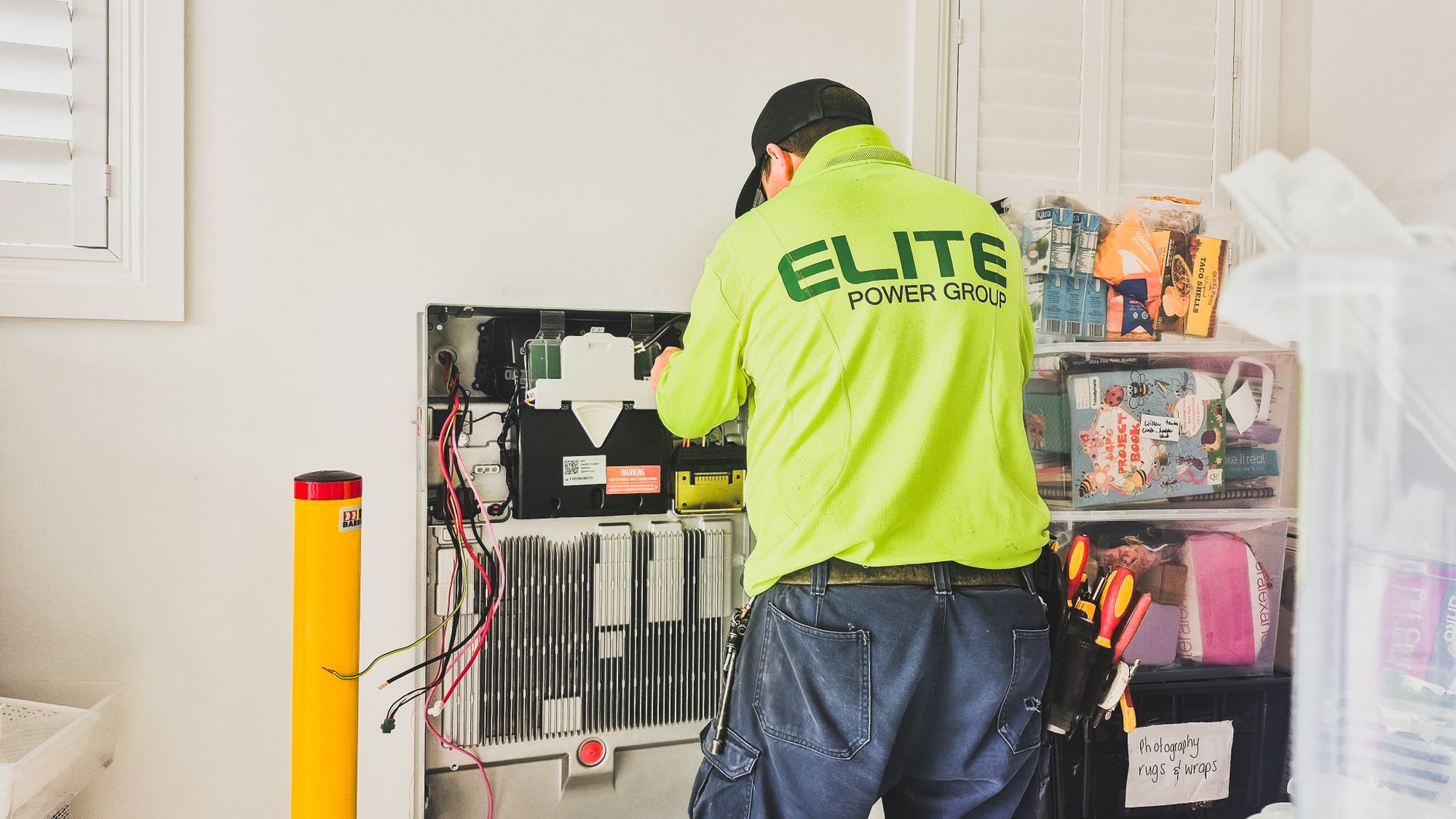 A technician installing a home battery system for uninterrupted Starlink power.