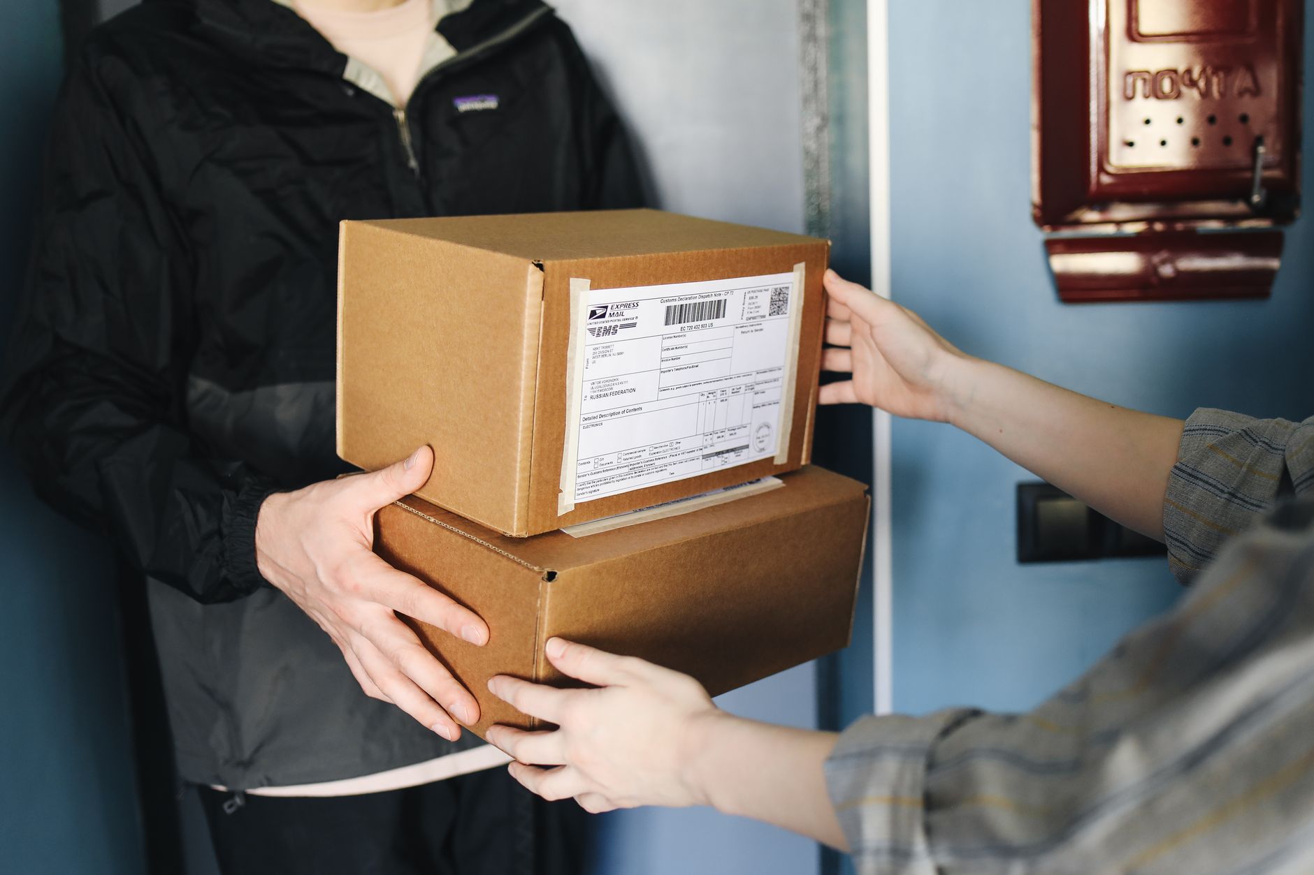 Hands exchanging a cardboard box during an equipment handoff
