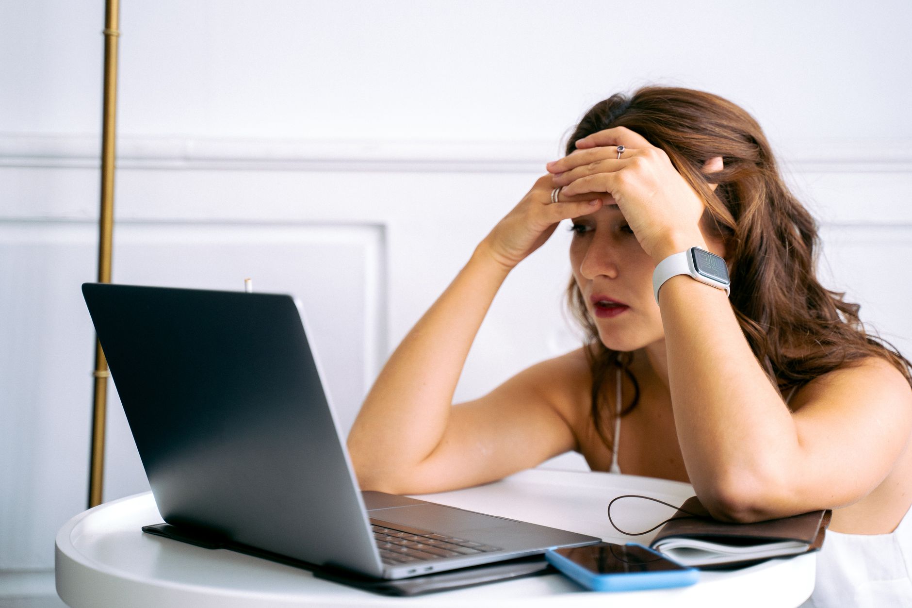 A person troubleshooting an internet problem using a laptop and smartphone