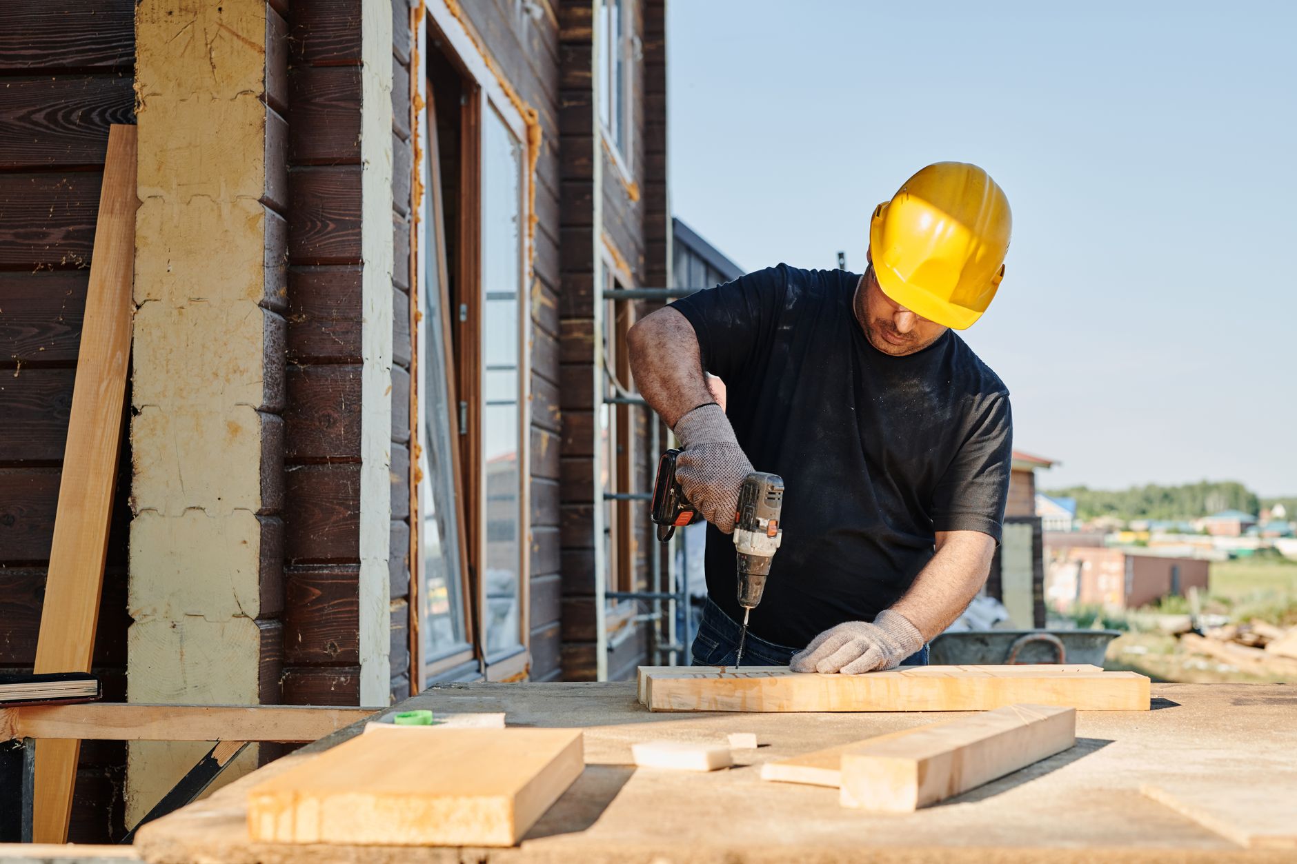Construction worker using a power drill outdoors, illustrating careful Starlink mount preparation.